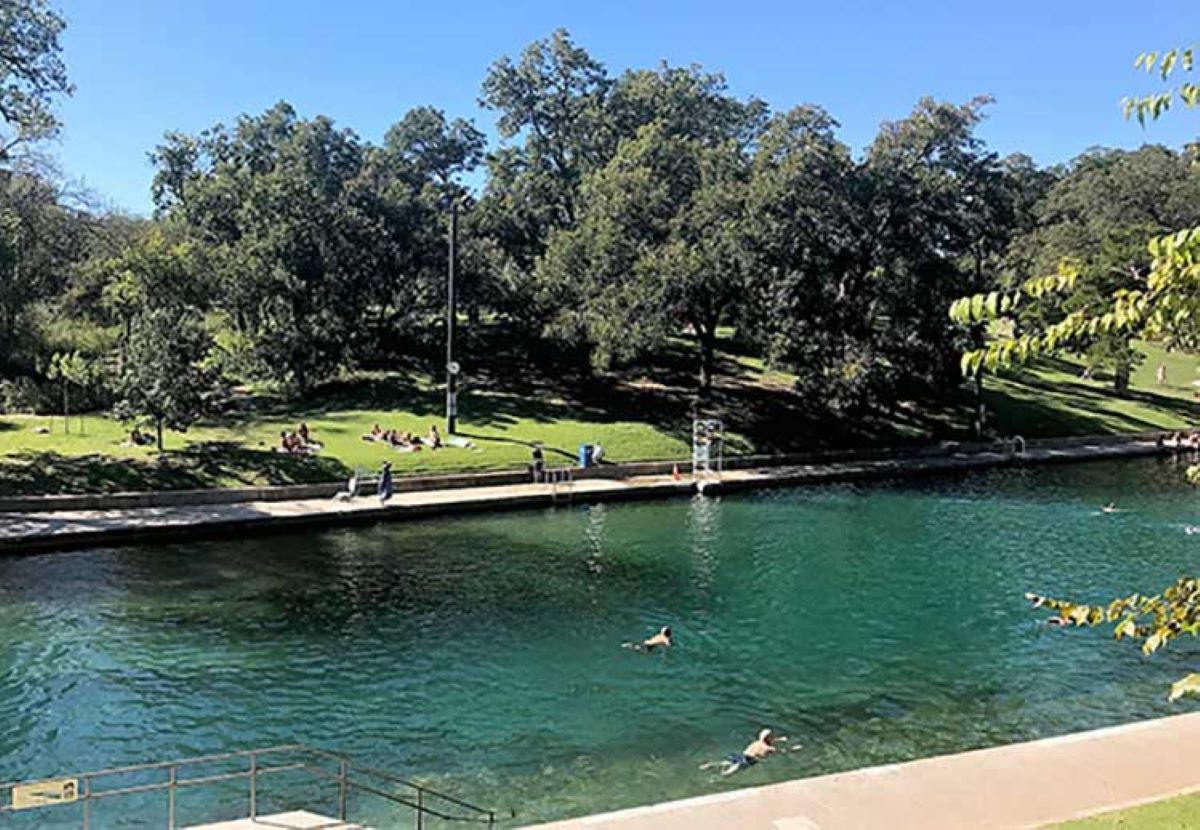 People swimming and picnicking at Barton Springs Pool in Austin, Texas